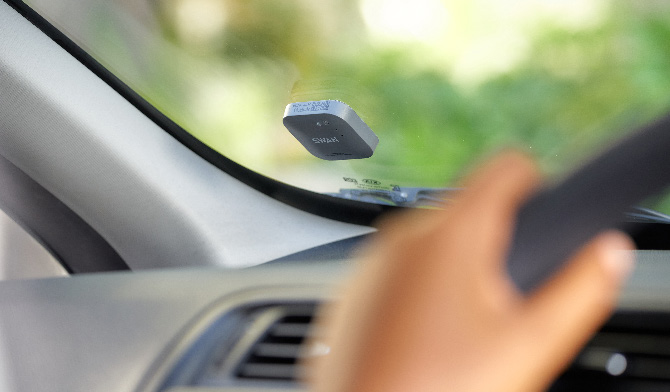 Le petit boîtier télématique autonome, sur le pare-brise, analyse en temps réel la conduite de l’automobiliste.